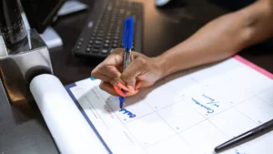 Person marking dates on a desk calendar to plan upcoming paid time off