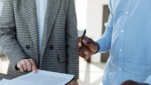 Two business partners reviewing a letter of intent before signing