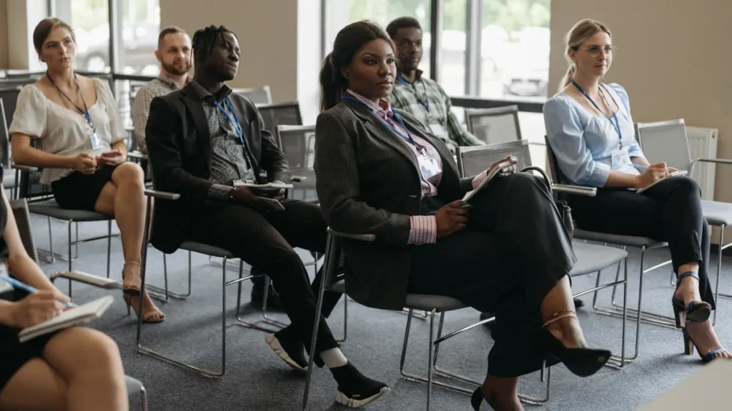 HR professionals taking notes while listening to a speaker at a training workshop